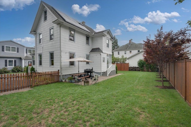 rear view of property with a patio area, a fenced backyard, and a lawn