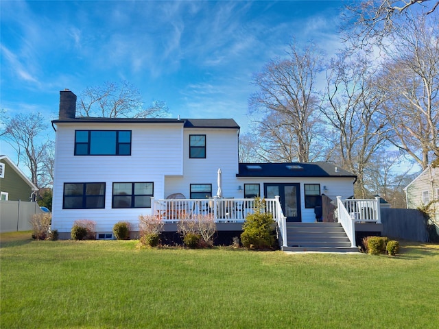 back of property with a lawn and a deck