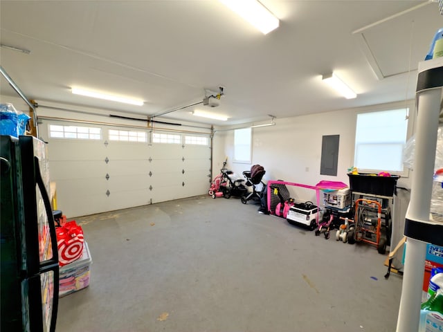 garage with a garage door opener, electric panel, and black fridge