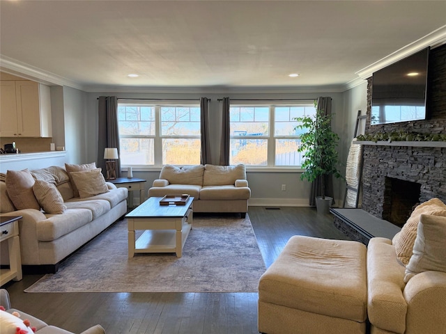 living room with dark wood-type flooring, plenty of natural light, and a stone fireplace