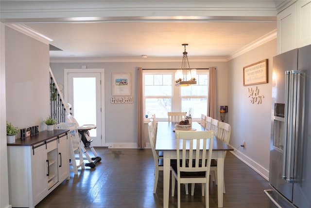 dining room with crown molding, dark hardwood / wood-style flooring, and an inviting chandelier