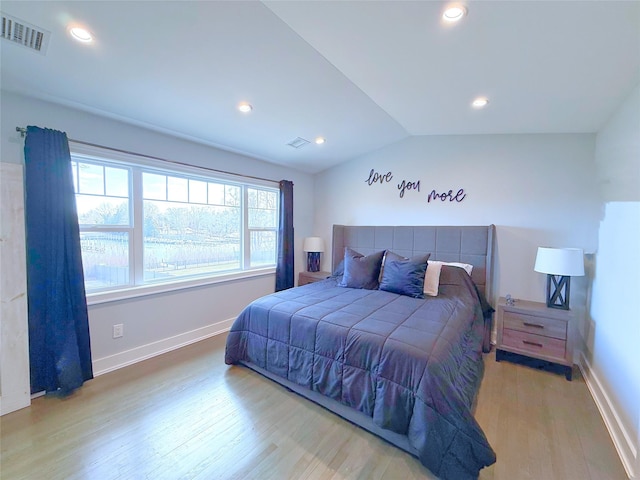 bedroom with vaulted ceiling and light wood-type flooring