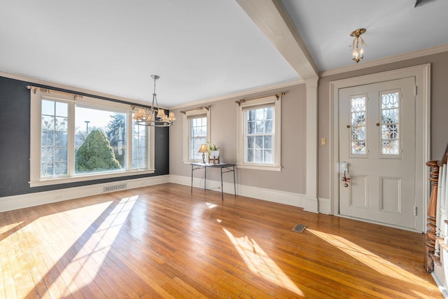 entryway featuring crown molding, an inviting chandelier, and light hardwood / wood-style flooring