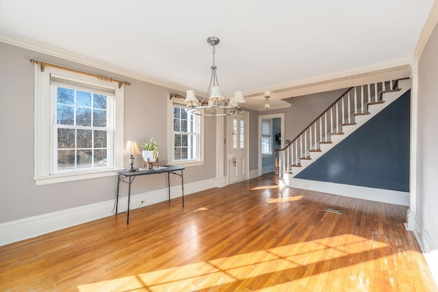 interior space with crown molding, wood-type flooring, and an inviting chandelier