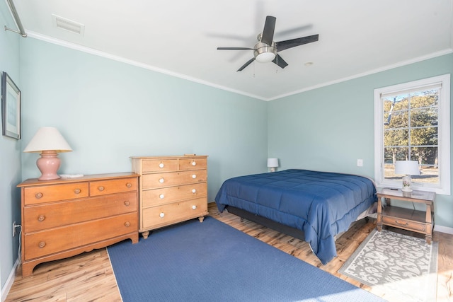 bedroom with hardwood / wood-style flooring, ceiling fan, and crown molding