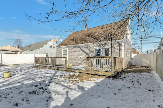 snow covered house featuring a wooden deck