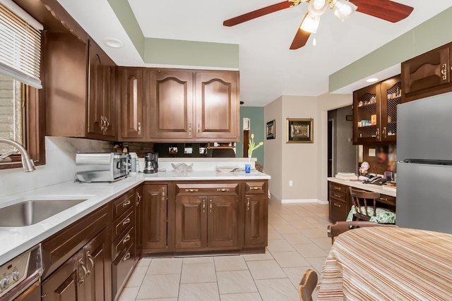 kitchen featuring built in desk, dishwasher, sink, light tile patterned floors, and ceiling fan