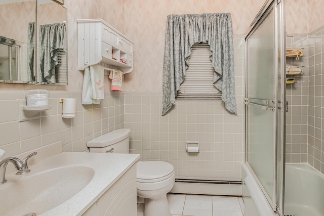 full bathroom featuring tile walls, shower / bath combination with glass door, baseboard heating, toilet, and tile patterned floors