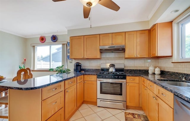 kitchen with dark stone counters, decorative backsplash, light tile patterned floors, stainless steel appliances, and crown molding