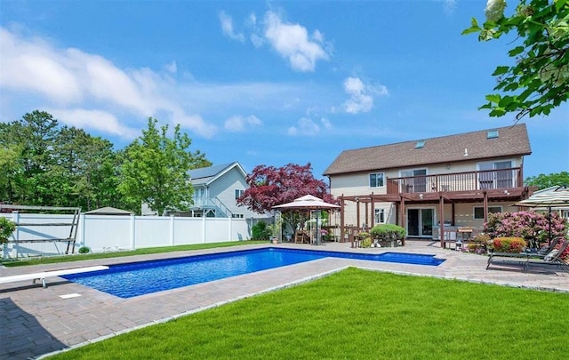 view of swimming pool with a patio, a diving board, a deck, a lawn, and a pergola