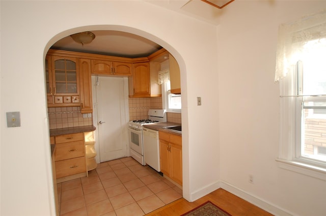 kitchen featuring light tile patterned flooring, sink, white appliances, and decorative backsplash