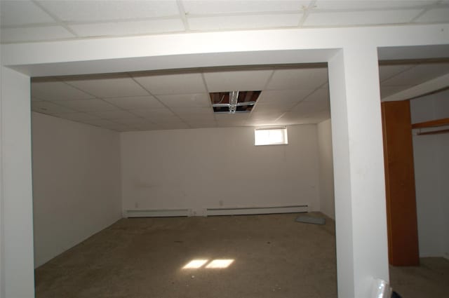 basement with a paneled ceiling and a baseboard radiator