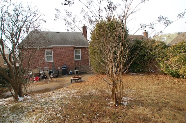 rear view of house featuring a patio area and an outdoor fire pit