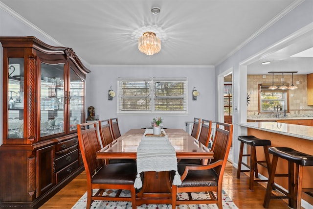 dining area with hardwood / wood-style flooring, ornamental molding, and a wealth of natural light