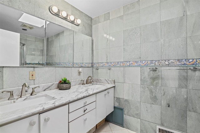 bathroom featuring tile patterned flooring, vanity, and tile walls