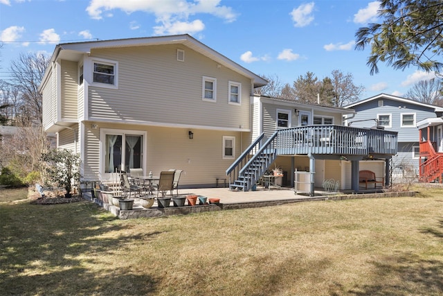 rear view of house featuring a yard, stairway, a wooden deck, and a patio area