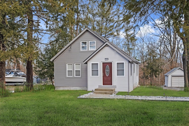 bungalow featuring a garage, an outdoor structure, and a front yard