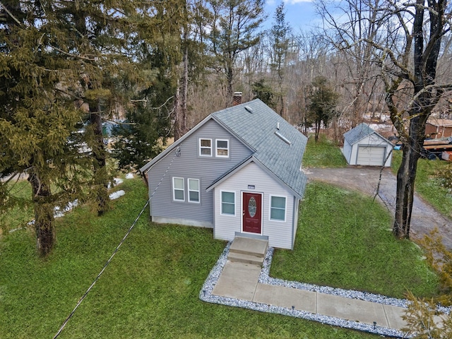 front facade featuring an outbuilding, a garage, and a front lawn