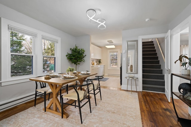 dining space featuring a baseboard heating unit and hardwood / wood-style floors