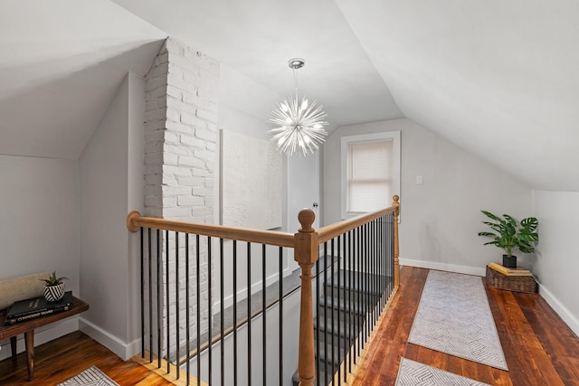 hallway featuring lofted ceiling, a notable chandelier, and dark hardwood / wood-style floors