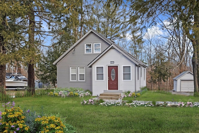 bungalow-style home with a garage, an outbuilding, and a front yard