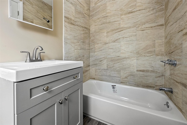 bathroom featuring tiled shower / bath and vanity