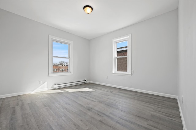 spare room featuring a baseboard radiator and wood-type flooring