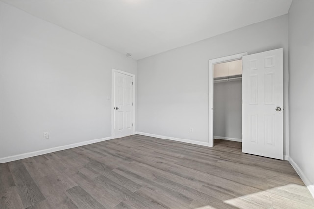 unfurnished bedroom with hardwood / wood-style flooring and a closet