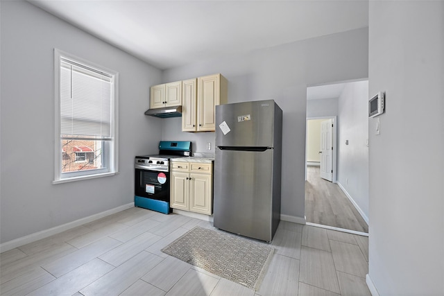 kitchen with cream cabinets, a baseboard radiator, and appliances with stainless steel finishes