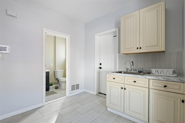 kitchen featuring sink and cream cabinetry