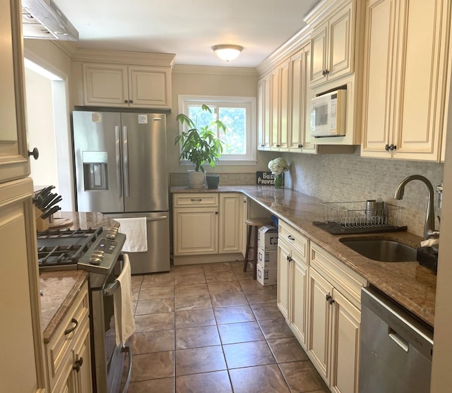 kitchen featuring stone counters, tasteful backsplash, sink, stainless steel appliances, and cream cabinets