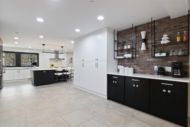 bar with recessed lighting, hanging light fixtures, and brick wall