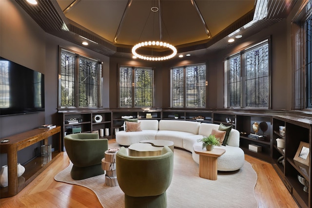 living area featuring a raised ceiling and wood finished floors