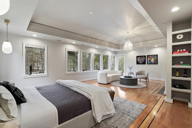 bedroom featuring a tray ceiling, recessed lighting, and light wood-style floors