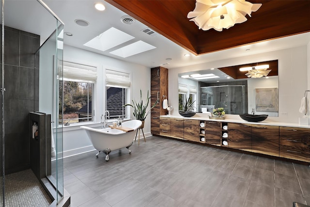 bathroom with a stall shower, visible vents, a freestanding bath, and vanity