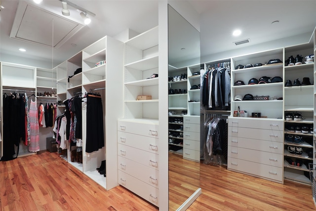 spacious closet with visible vents, wood finished floors, and attic access