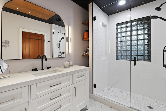 bathroom with a shower stall and vanity