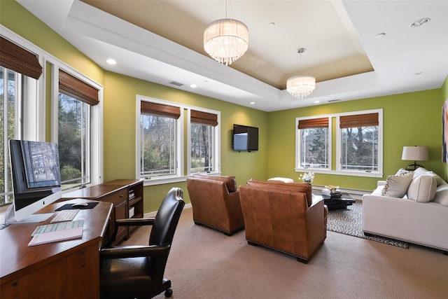 carpeted office space with a chandelier, a raised ceiling, a wealth of natural light, and baseboards