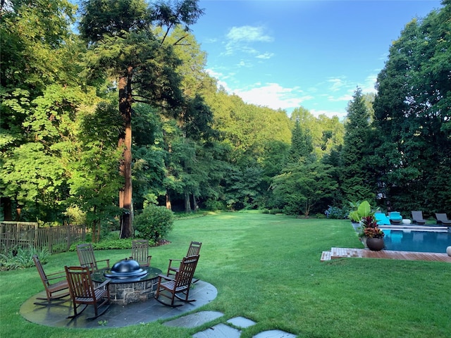 view of yard featuring a fenced in pool, a patio area, fence, and a fire pit