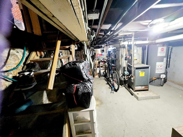 unfinished basement featuring a heating unit and water heater