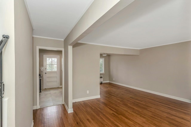 entrance foyer featuring crown molding, baseboards, wood finished floors, and a healthy amount of sunlight