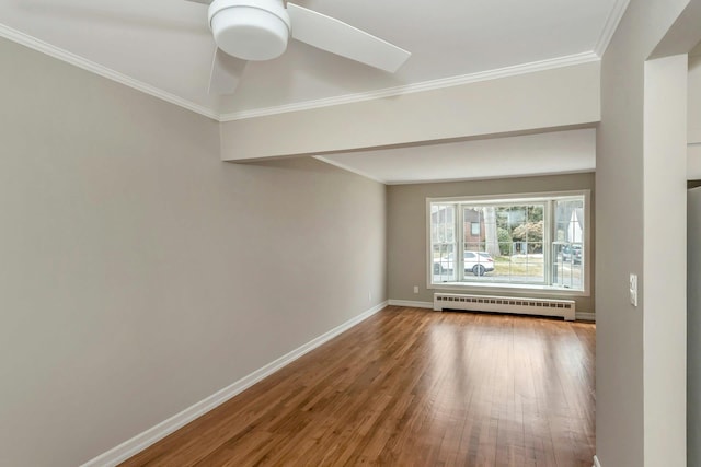 unfurnished room with a baseboard radiator, baseboards, wood finished floors, and ornamental molding