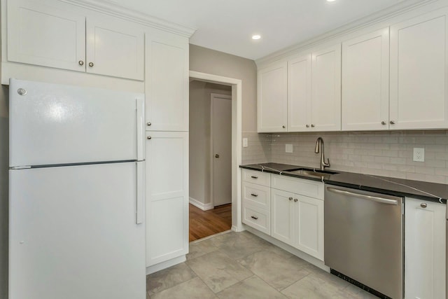 kitchen with dishwasher, dark countertops, freestanding refrigerator, and white cabinets