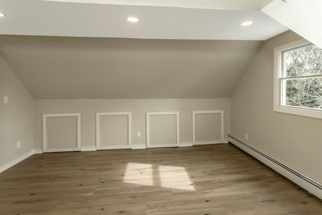 bonus room featuring lofted ceiling, baseboard heating, wood finished floors, and recessed lighting