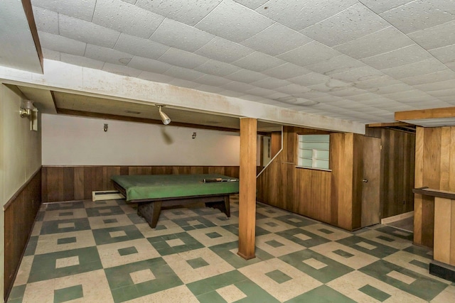 playroom with a baseboard heating unit, dark floors, wainscoting, and wooden walls