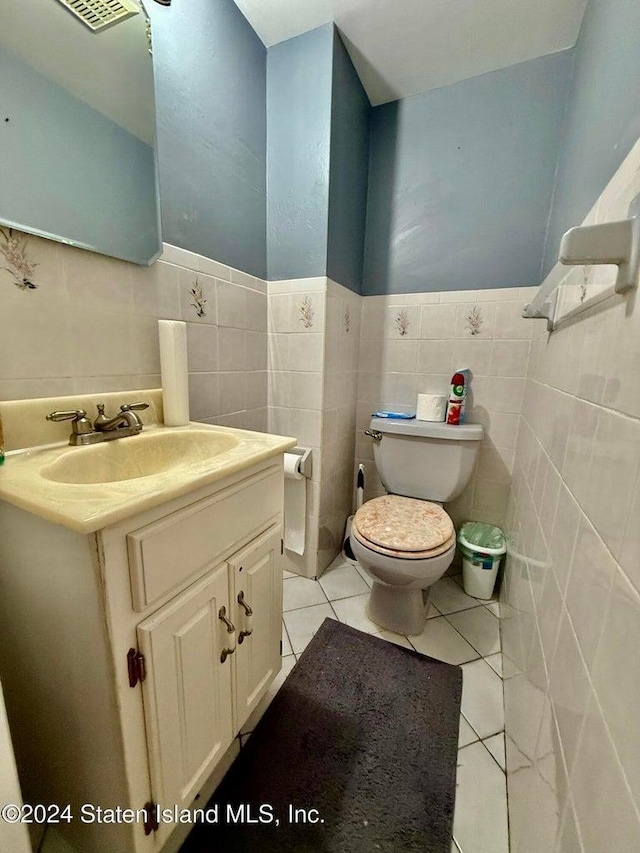 bathroom featuring tile patterned flooring, vanity, tile walls, and toilet