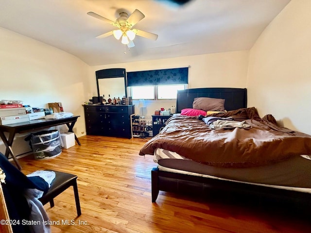 bedroom featuring wood-type flooring, lofted ceiling, and ceiling fan