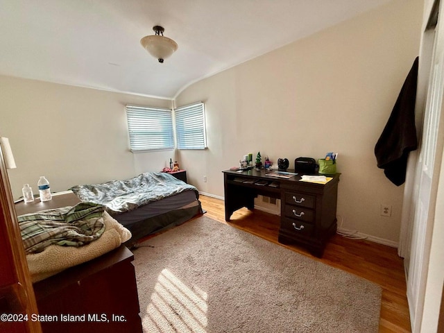 bedroom featuring lofted ceiling and light hardwood / wood-style floors