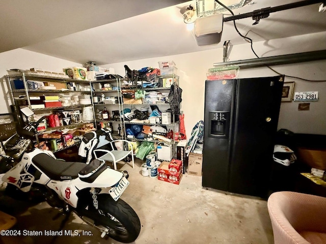 interior space featuring a garage door opener and black fridge