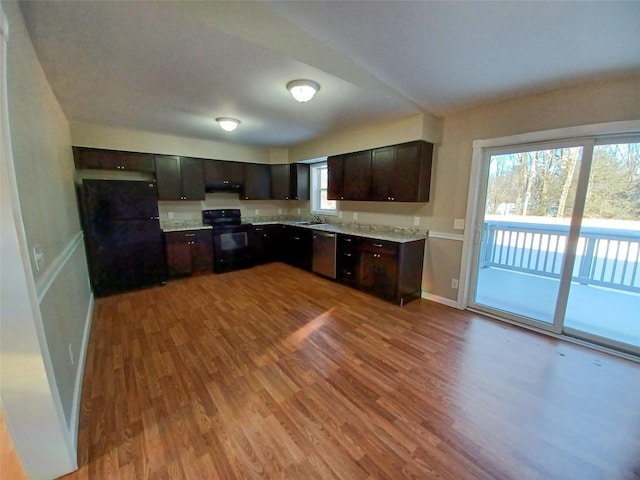 kitchen with light wood-type flooring, dark brown cabinetry, sink, and black appliances